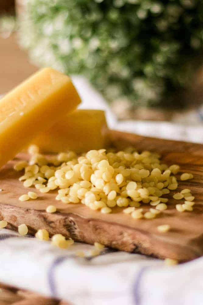 Beeswax pellets on wood cutting board. 