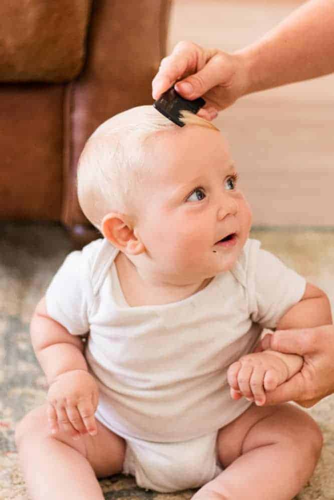 Combing out cradle cap on a baby.
