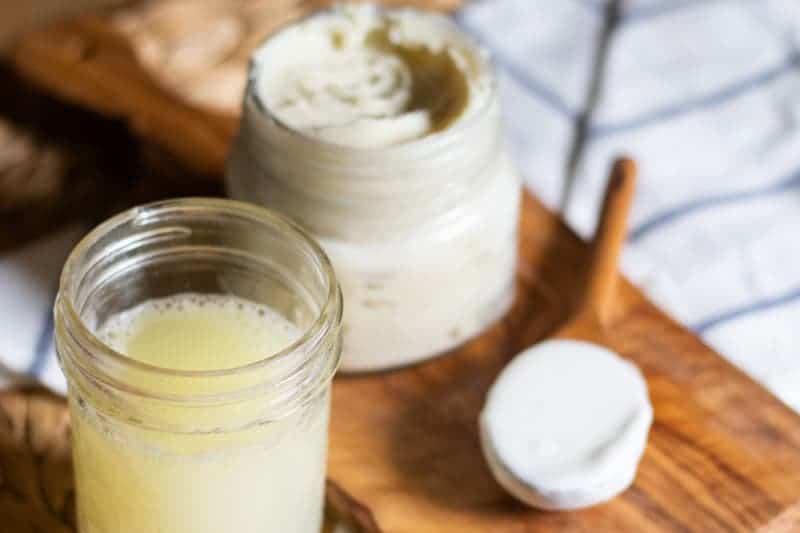 Face moisturizer, face cleanser, and face mask in mason jars on wooden board. 