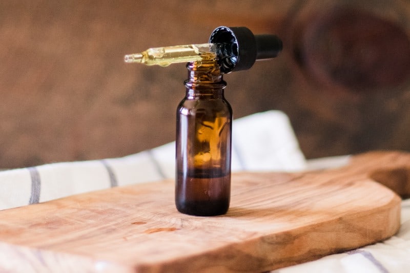 Vitamin E oil bottle with dropped lid sitting on top of it.