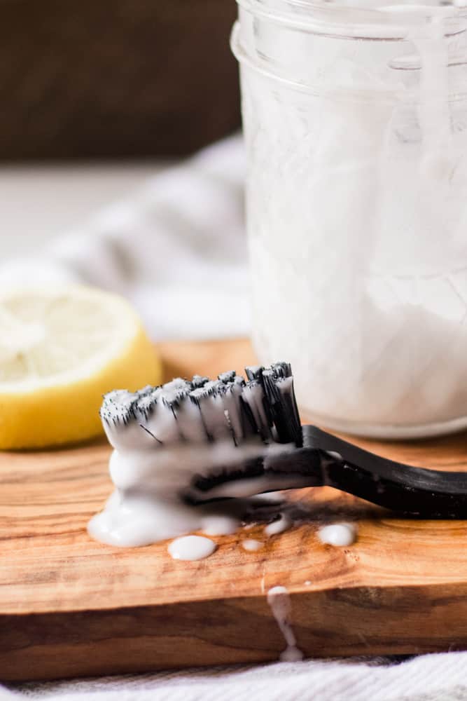 Black nylon toothbrush with grout cleaner on it.