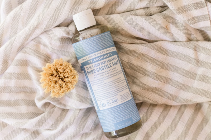 Dr. Bronners Castile Soap on white and gray striped towel.