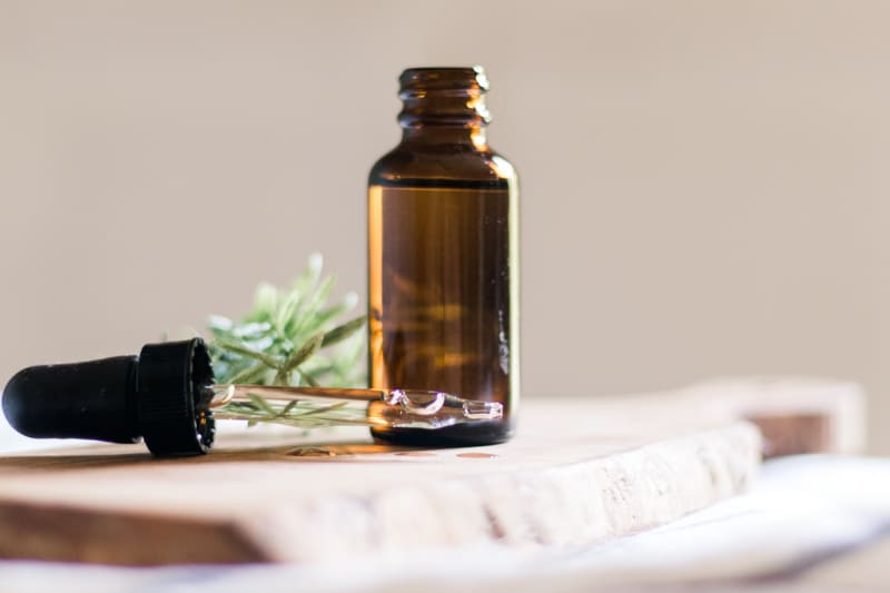 Dropper top of beard growth oil laying on its side next to the bottle.