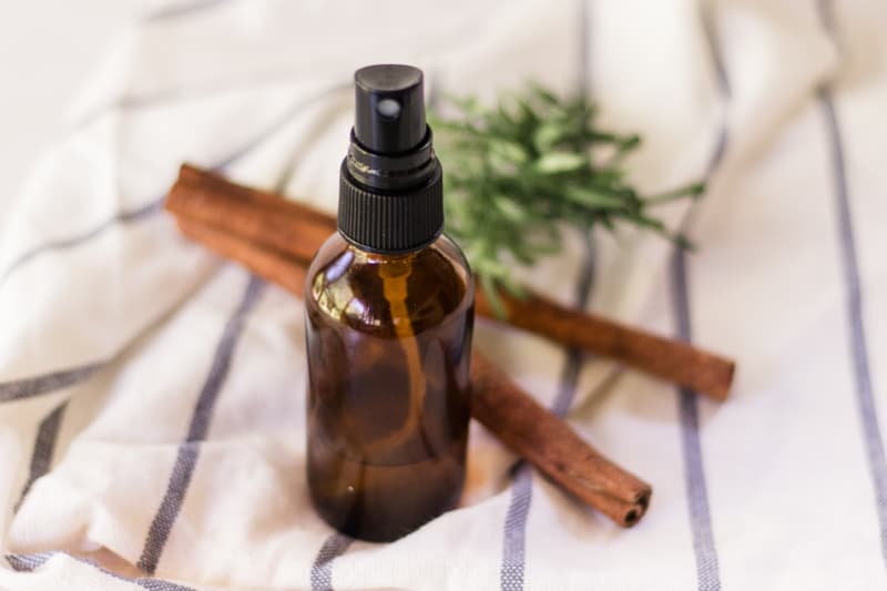 Amber bottle with mouth freshener sitting on blue and white striped towel.