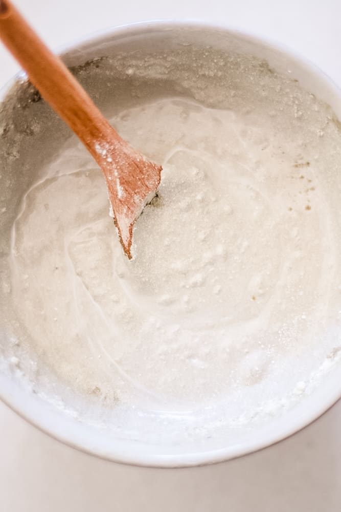 Bentonite clay rash cream in small bowl with wooden spoon.