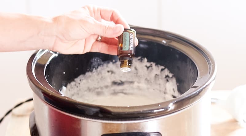 Adding essential oils to crockpot of soap.