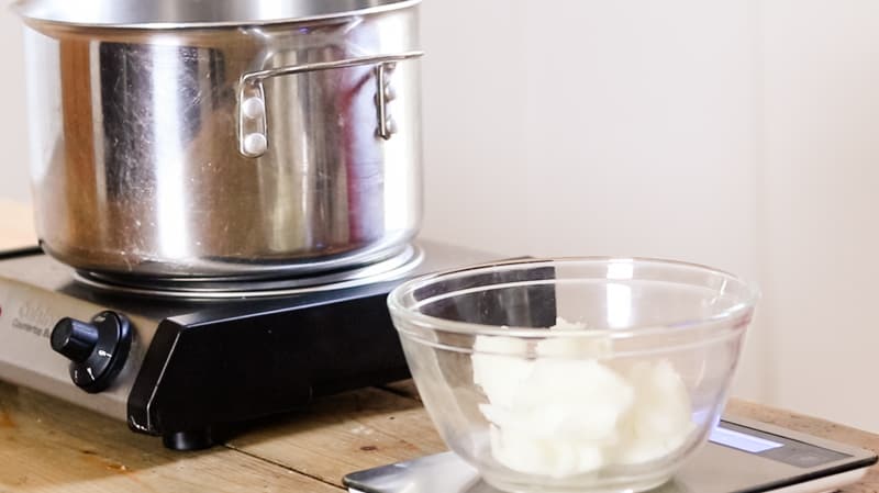 Measuring shea butter on a digital scale for soap making.