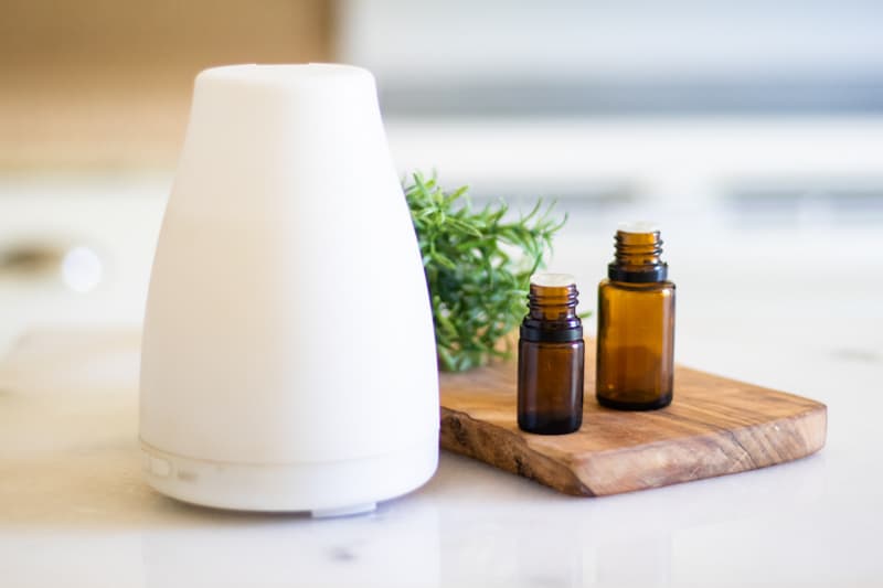 Essential oil diffuser with essential oil bottles next to it.