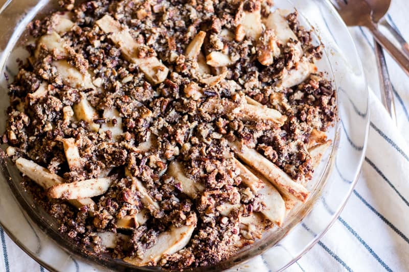 Apple pie with cinnamon crumble in glass pie pan.