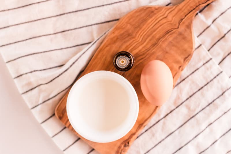 Natural protein treatment for hair with yogurt, egg and lavender on wooden board.