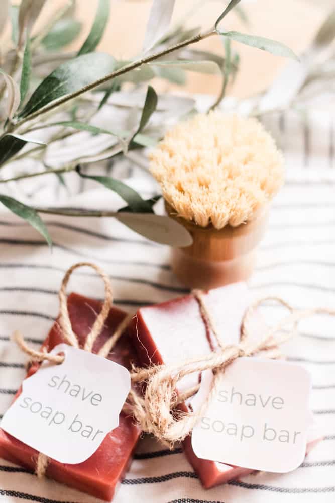 Two shave soap bars on white and black striped towel.