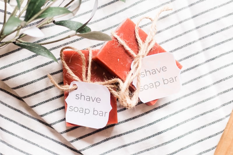 Deep red shave soap bars with labels tied around them with hemp rope.