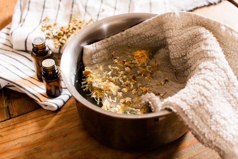 Soaking white towel in a pot of boiling water to soak face.