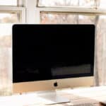 Imac with a clean screen on a wooden desk.