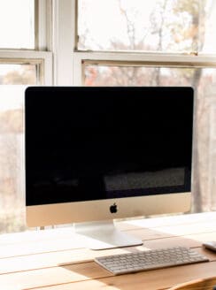 Imac with a clean screen on a wooden desk.