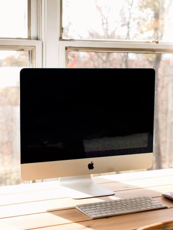 Imac with a clean screen on a wooden desk.