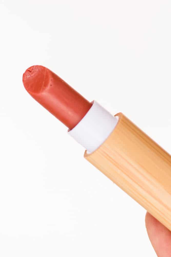 Extending lipstick from its tube.