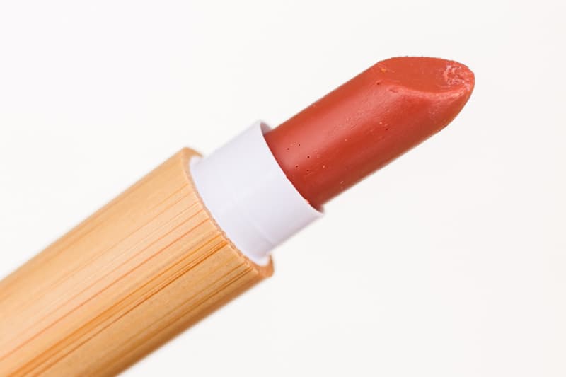 Bamboo lipstick tube with red lipstick coming out the top.