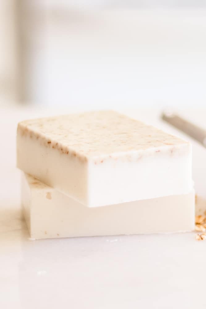 Two decorative soap bars using a oatmeal and honey soap recipe sitting on white marble.