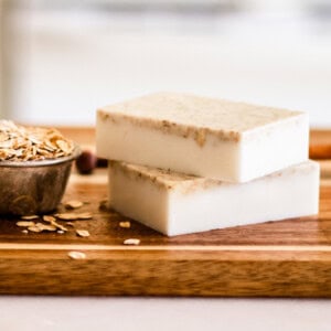 Homemade honey oatmeal soap bars on wooden cutting board.