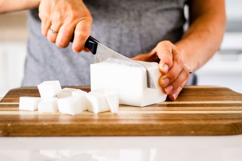 Chopping up a shea butter soap base in preparation to make a soap bar.