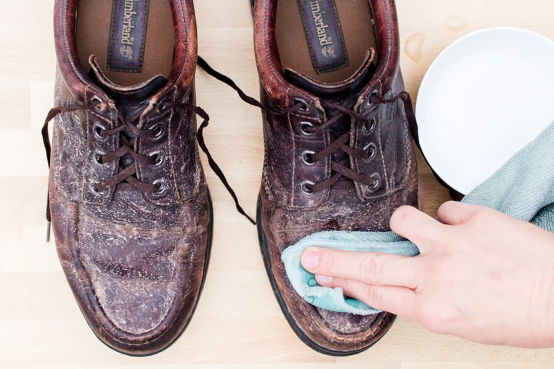 Wiping down leather shoes with vinegar and water. 