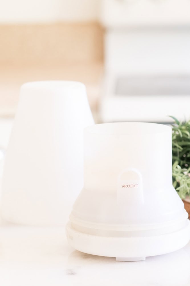 White essential oil diffuser on white table.