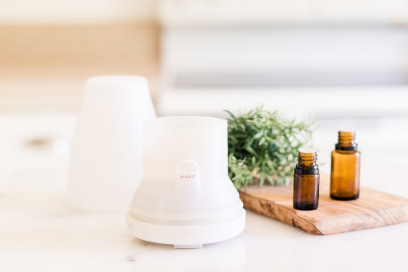 White essential oil diffuser on white marble table.