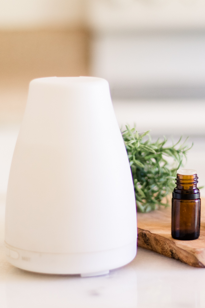 Small white essential oil diffuser on table.