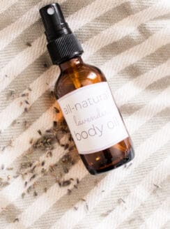 Homemade body oil in a glass dropper bottle with dried lavender sprigs.