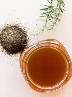 Green tea hair rinse in shallow glass container with loose leaf green tea.