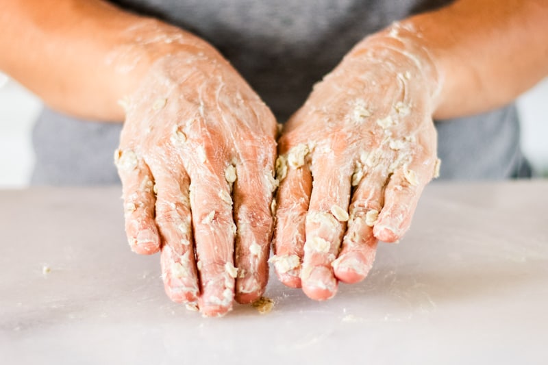 Massaging the hand mask into the hands.