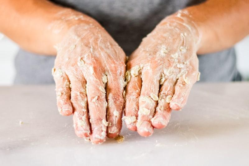 Massaging the hand mask into the hands.