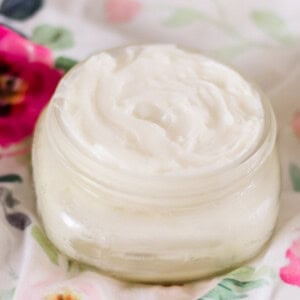 Lavender baby lotion with rose petals on soft tea towel.