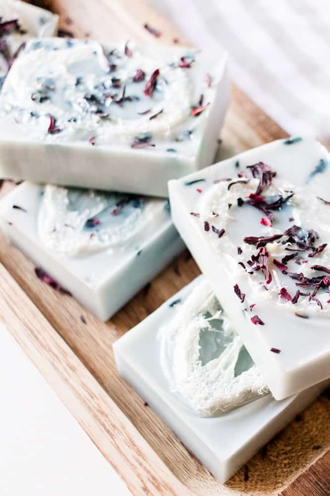 Exfoliating soap bars stacked on a wooden soap bar drying tray.