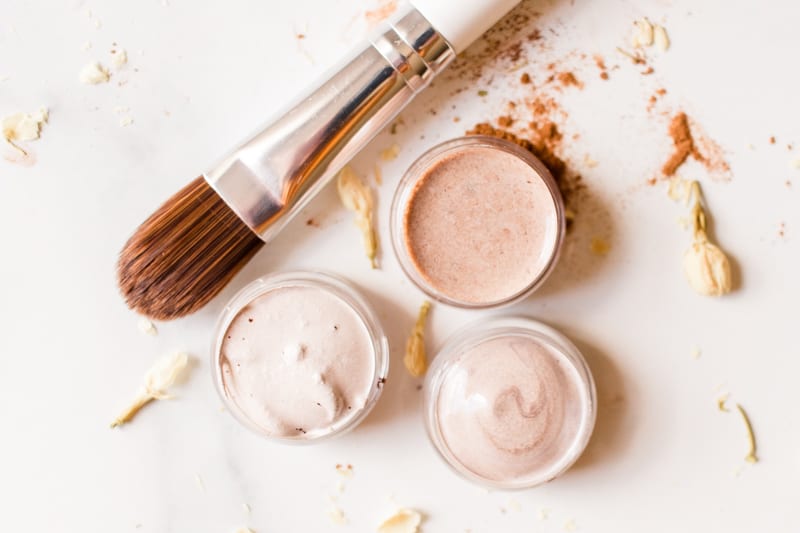 3 homemade concealers in small glass jars with a fine brush applicator.