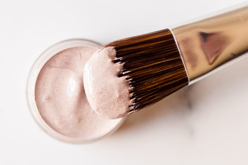 Homemade concealer for dark circles being applied with a fine applicator.