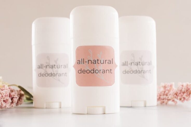 3 DIY natural deodorants with white containers and fragrant flowers.