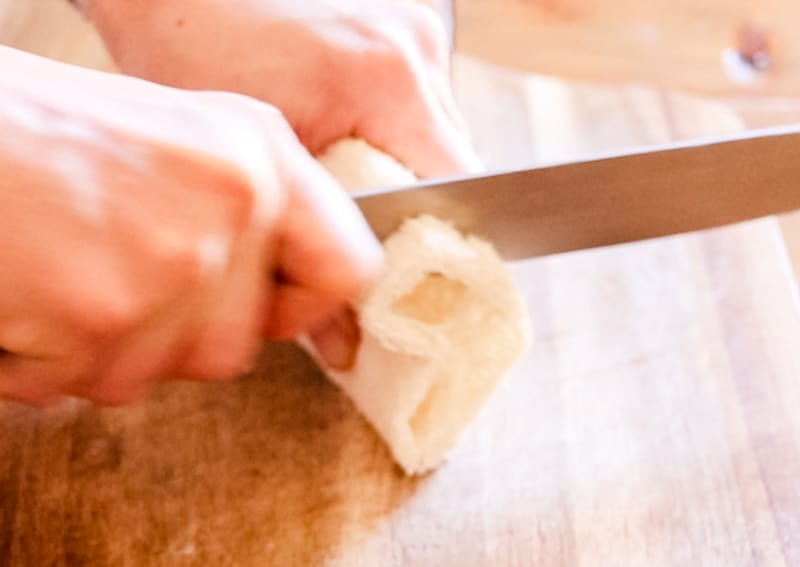 Cutting a loofah with a sharp knife to add to the loofah soap molds.