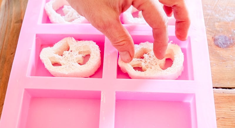 Placing the sliced loofa pieces into the silicone soap molds.