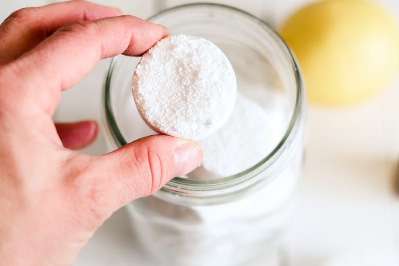 DIY dishwasher tabs being added to an airtight storage jar.