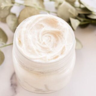 A DIY night cream, whipped with natural ingredients and green leaves in the background.