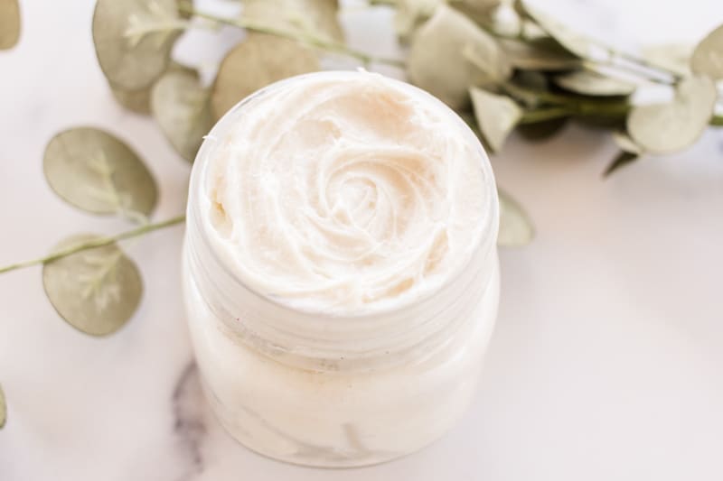 A DIY night cream, whipped with natural ingredients and green leaves in the background.