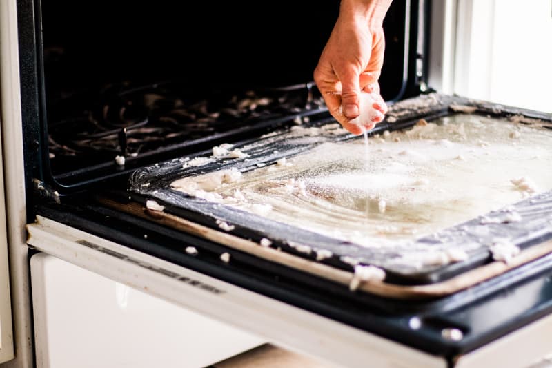 Cleaning an oven glass with a natural DIY oven cleaner.