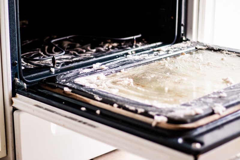 Stainless steel oven with a DIY oven cleaner soaking into the dirty grime.