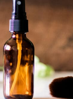 Glass bottle of homemade setting spray on a bathroom vanity.