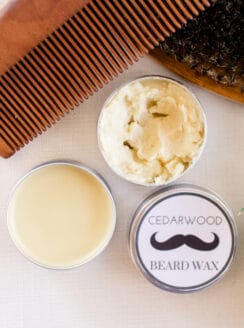 Homemade mustache wax and beard brush and comb on white vanity.