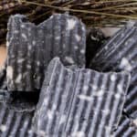 Stack of homemade soap bars with textured sides, white splotches and fancy tops.