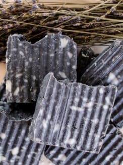 Stack of homemade soap bars with textured sides, white splotches and fancy tops.