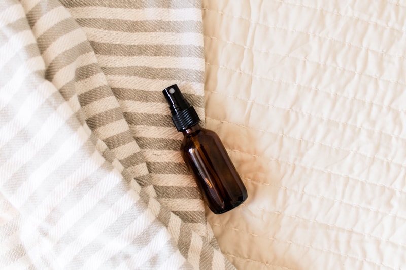 Homemade bed bug spray on a neatly made bed.